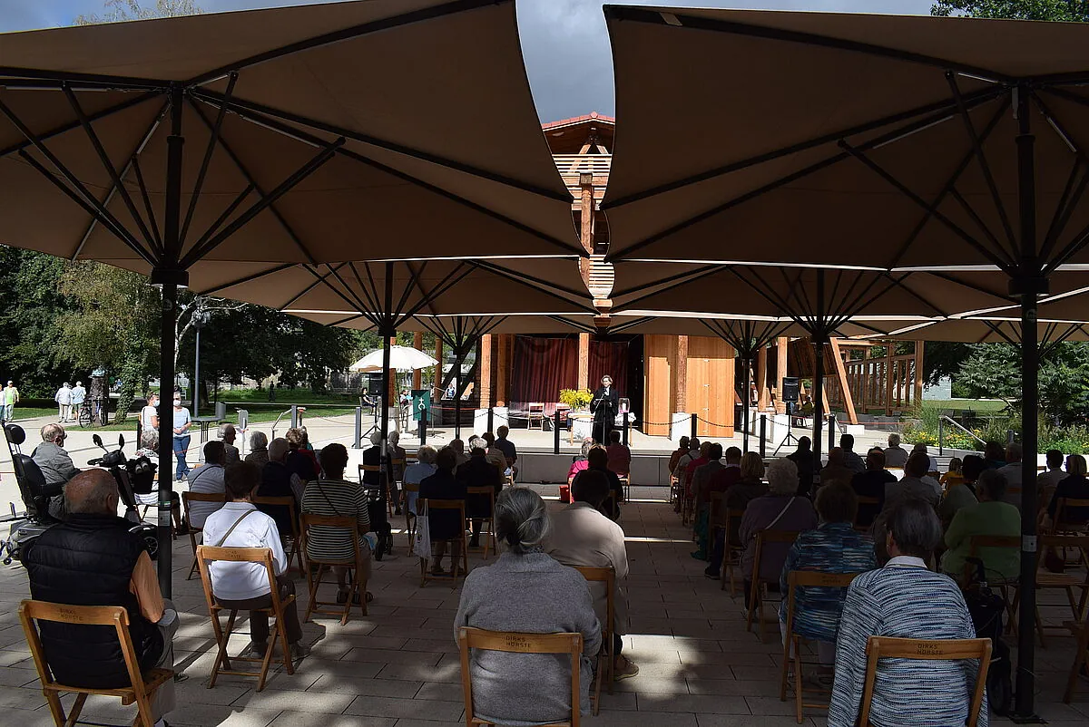Foto beim Kurpark-Gottesdienst von hinten mit Sicht über die Gemeinde auf die Bühne mit Altar
