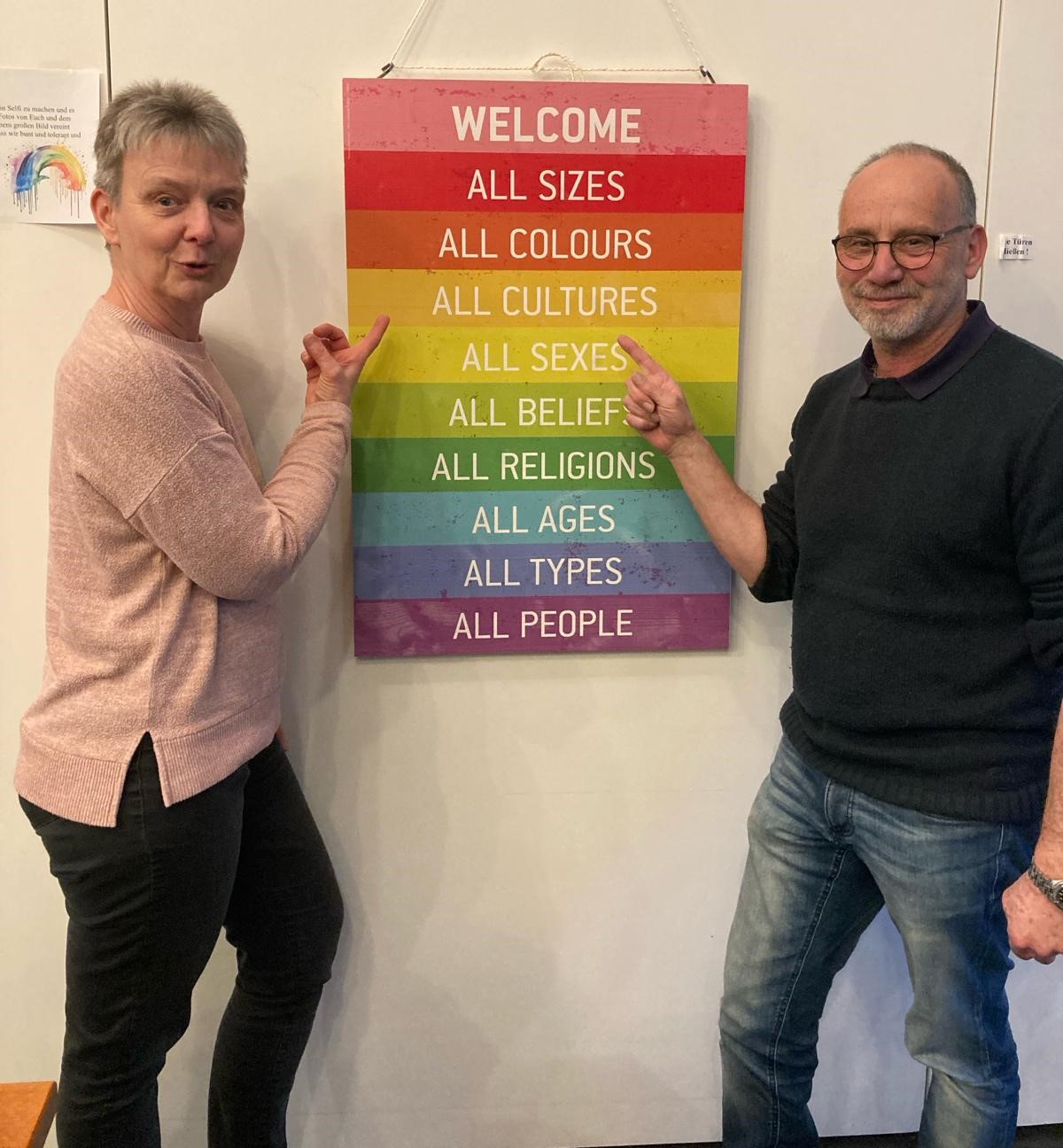 Foto: 2 Besucher stehen vor dem Welcome-Bild mit seinen Aufforderungen